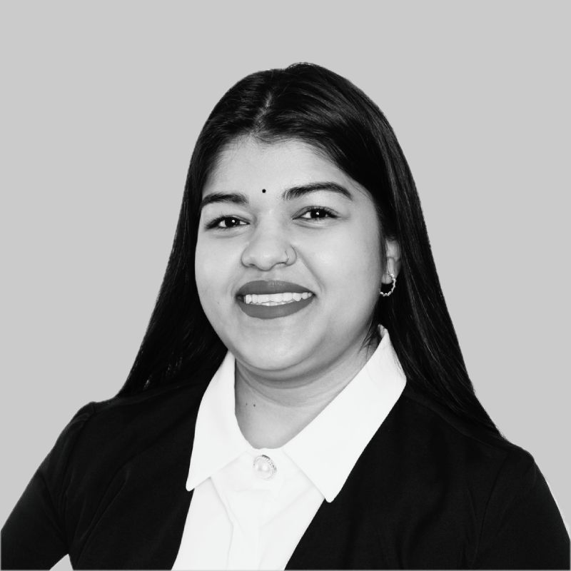 Professional headshot of Tasmika Barath in black and white with a soft grey background